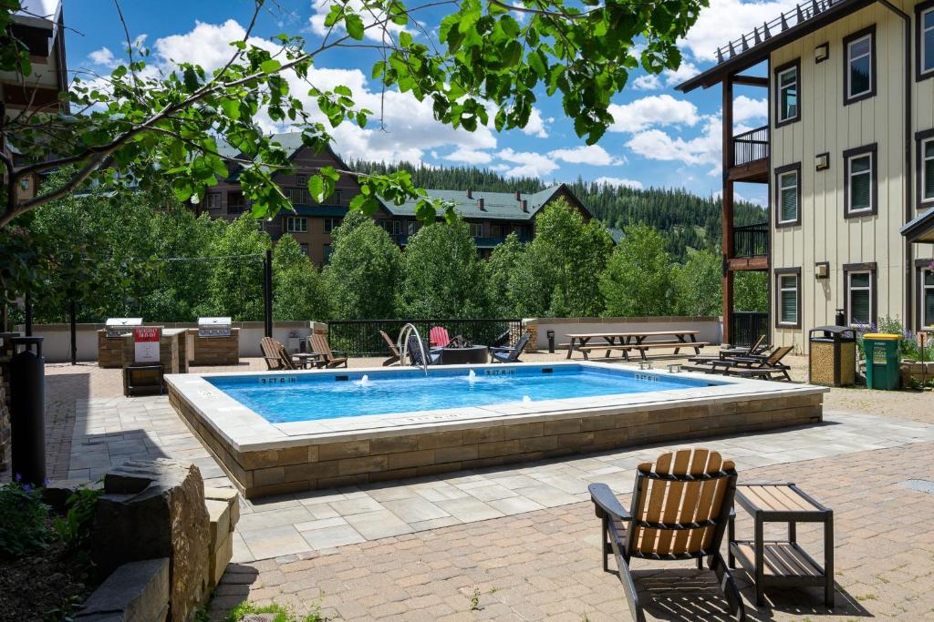 a swimming pool in a patio with two chairs next to a building at Fraser Crossing cabin in Winter Park