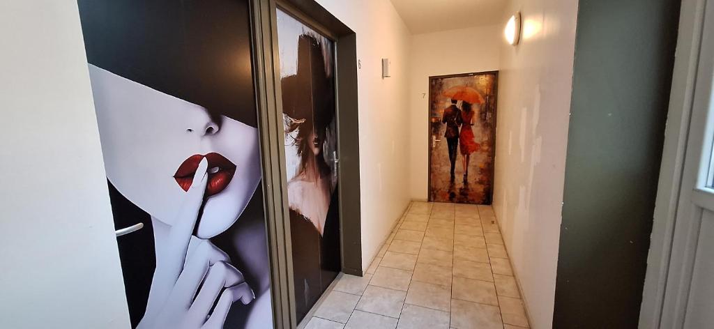 un pasillo con fotos de mujeres en las paredes en hôtel- restaurant le Saint Quentin, en Saint-Quentin