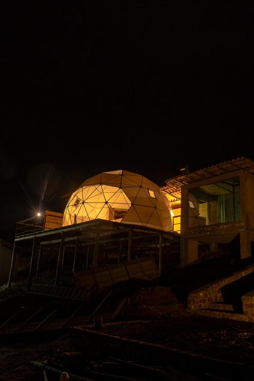 un edificio abovedado con una cúpula de cristal por la noche en Namora Domo Experience, en Cajamarca
