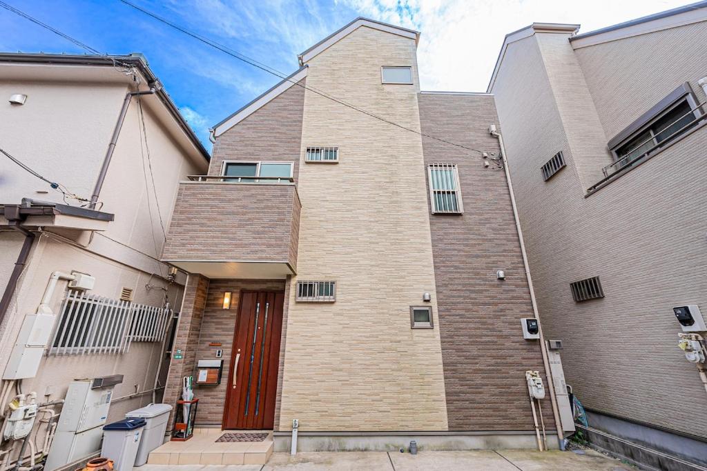 a large brick building with a red door at Anzu 4 Bed rooms Villa 5 minutes walk from Keise line Edogawa station in Tokyo