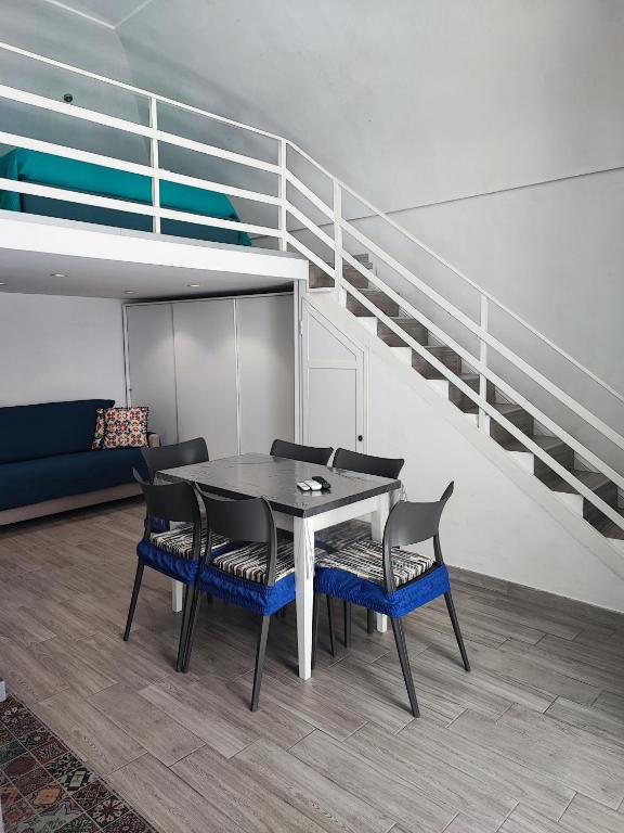 una sala da pranzo con tavolo, sedie e scale di La Perla del Borgo Casa Vener a Vieste