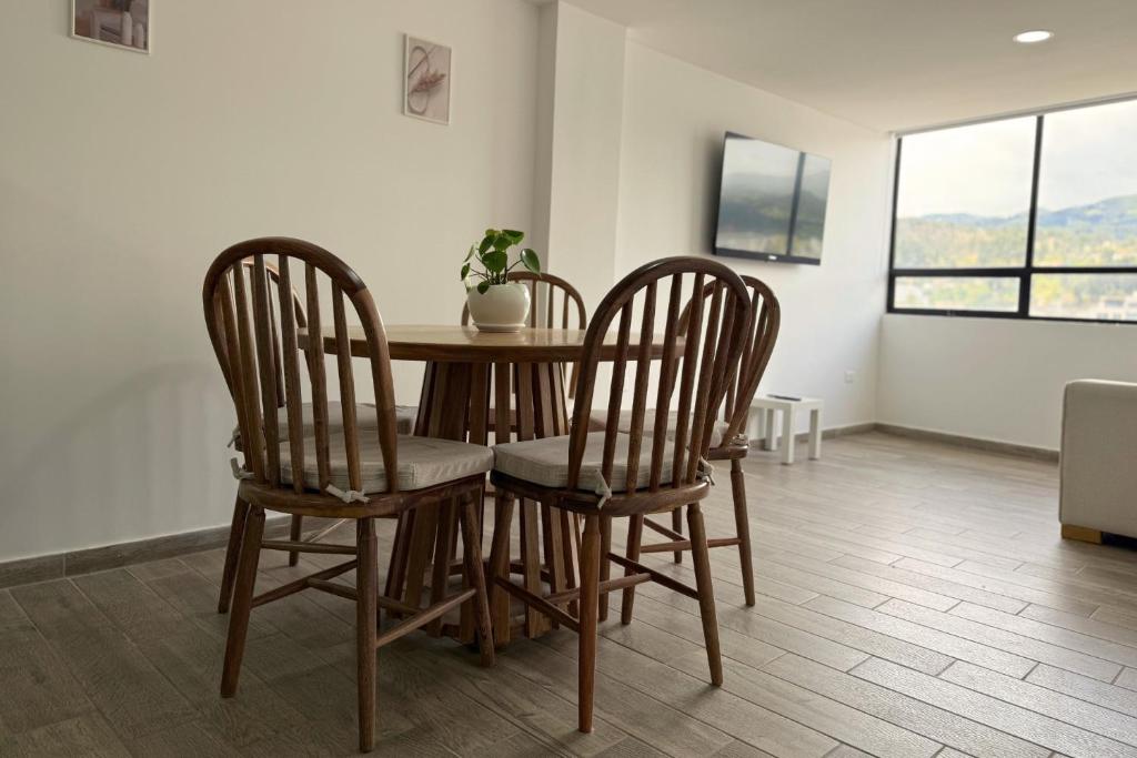 a table and chairs in a room with a window at Acogedor Apartamento Con Vista Panoramica in Sogamoso