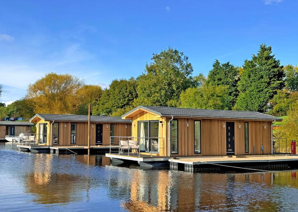 una hilera de cabañas de madera en un cuerpo de agua en York Marina, en Naburn