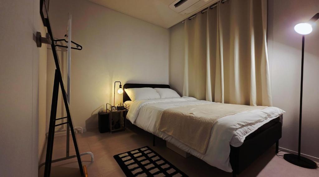 een kamer met een bed, een statief en een camera bij Urban Retreat 3-Min Walk from Achasan Station, 15-Min to Seongsu, Tranquil Space for Relaxation in Seoul
