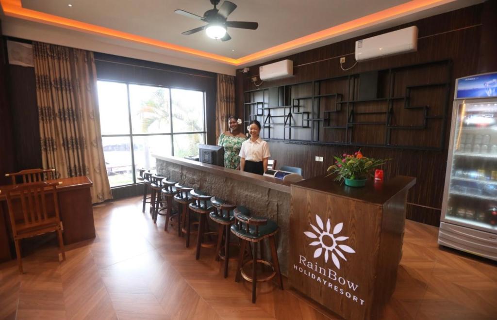 dos mujeres de pie en un bar en un restaurante en Rainbow Hoilday Resort, en Nadi