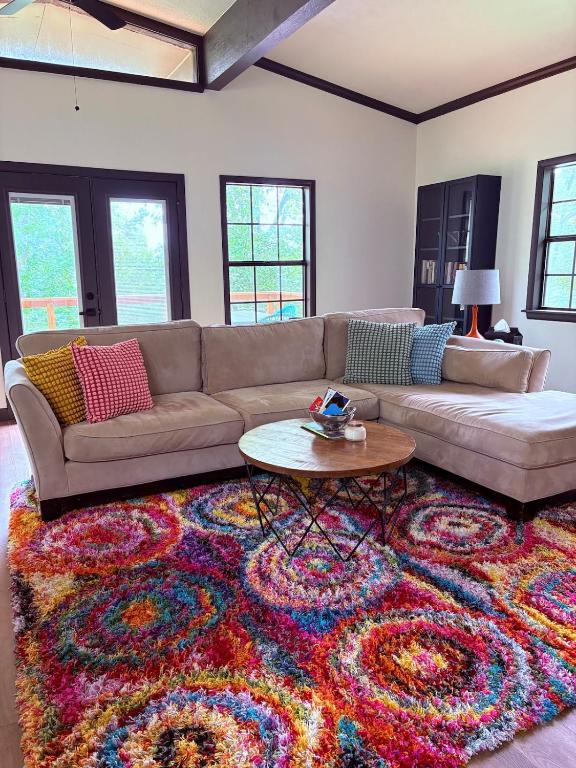 a living room with a couch and a colorful rug at Modern Mountainside Cabin in Bella Vista