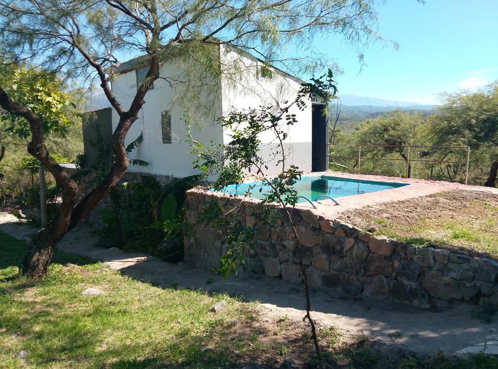 une maison avec une piscine et un mur en pierre dans l'établissement Finca de montaña agua Gracian, à Pomancillo