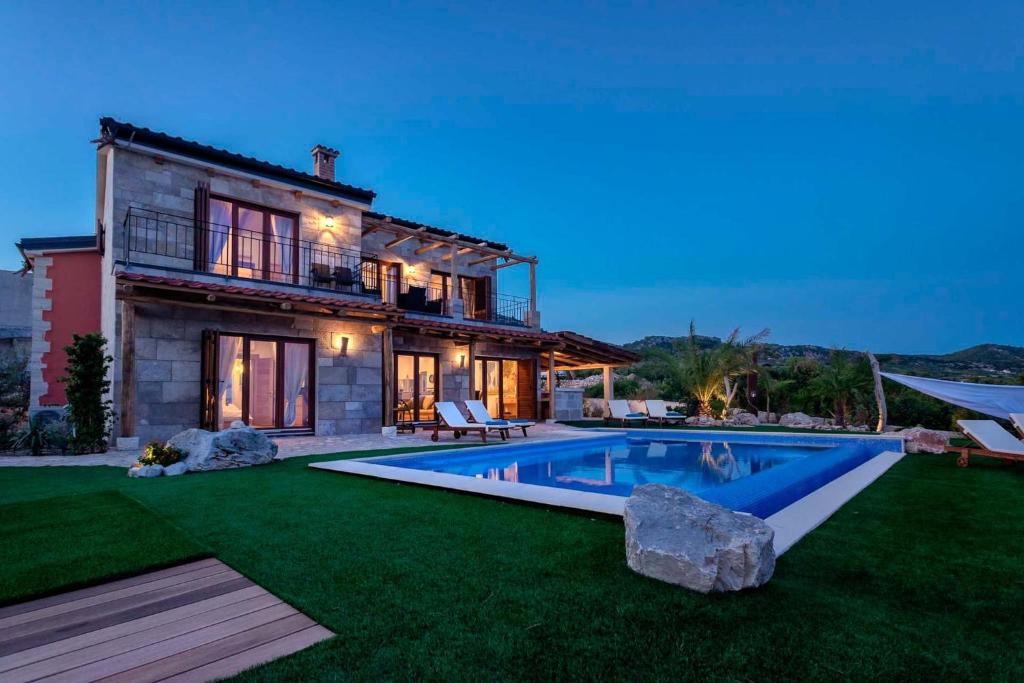 a house with a swimming pool in the yard at Astounding Hvar Villa 4 Bedrooms Villa Crystal Hvar 1 Mesmerizing Sea Views & Private Infinity Pool in Hvar