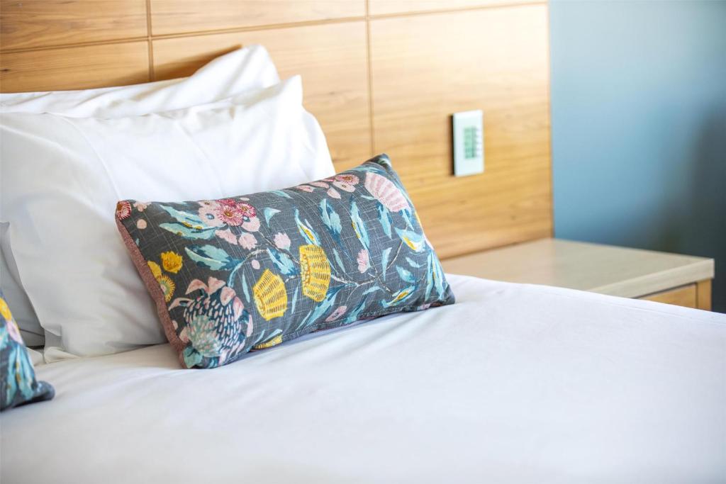 ein Bett mit zwei Kissen darauf in der Unterkunft Nightelier Devonport Gateway Hotel in Devonport