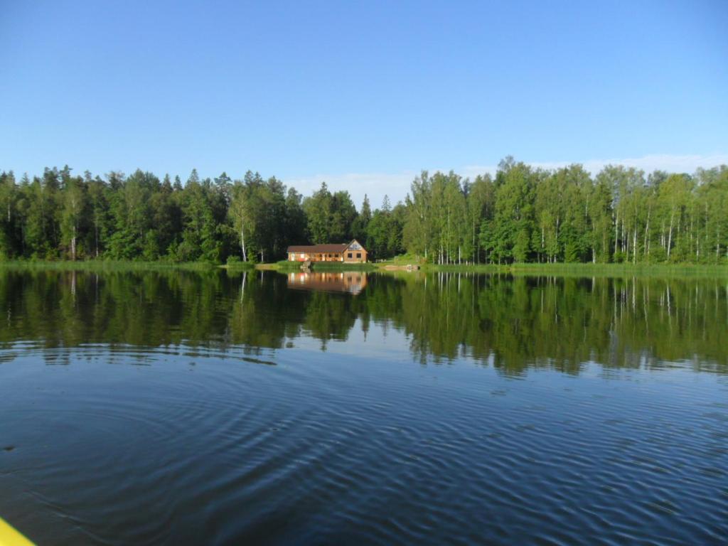 a house sitting on the shore of a lake at Võistre Holiday Center in Võistre