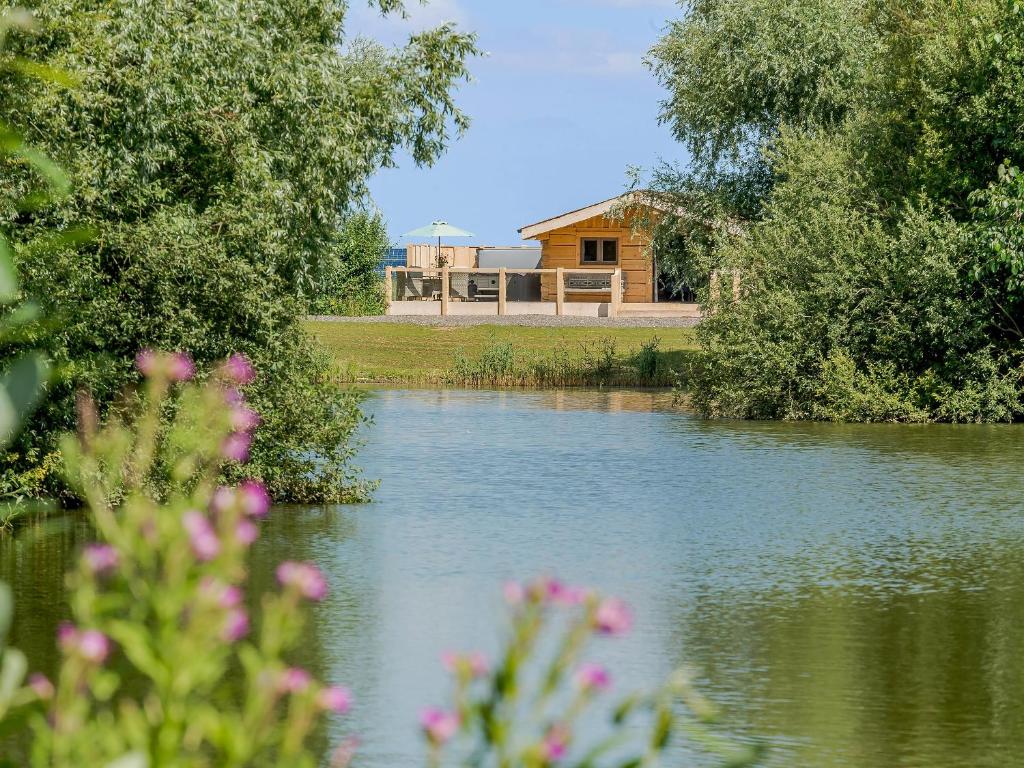 a view of a lake with a cabin in the background at Kingfisher Cabin in Croft