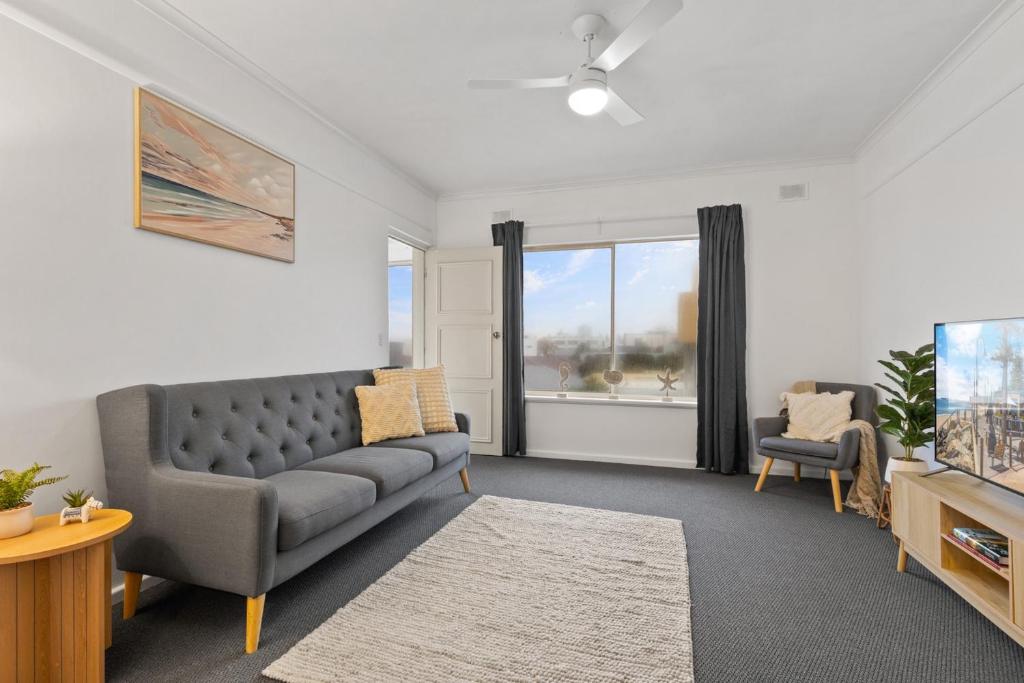 グレネルグにあるBeachside 2-Bed Apartment with Balcony Viewsのソファとテレビのあるリビングルーム