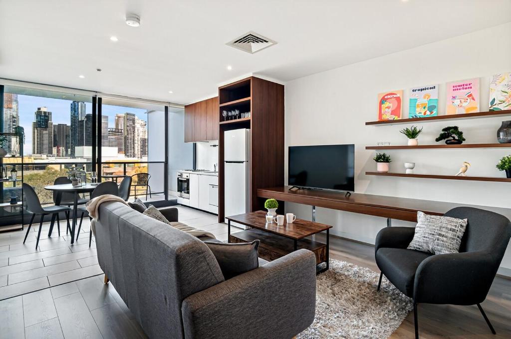 a living room with a couch and chairs and a television at Modern 2B2B Apt near Crown with Parking and City Views in Melbourne