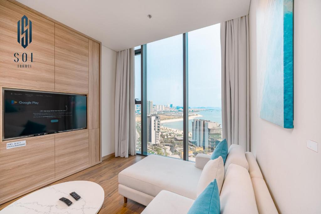 a living room with a white couch and a large window at À La Carte Homestay By Sol Travel in Kon Rung (1)