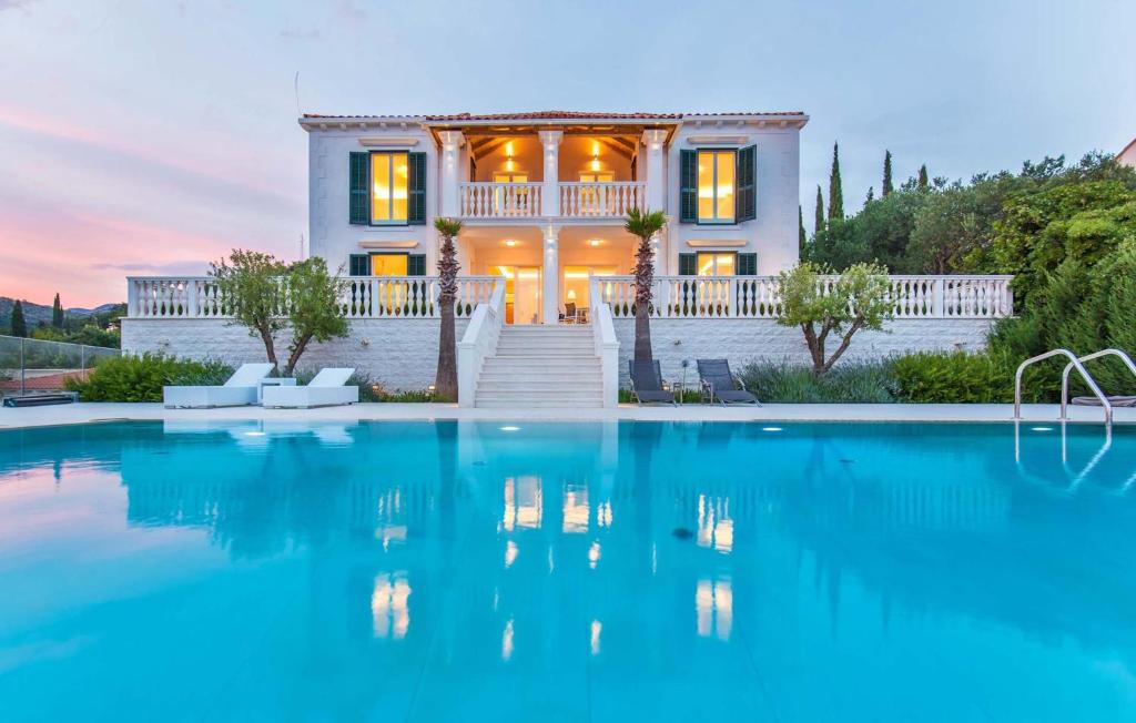 eine Villa mit einem Swimmingpool vor einem Haus in der Unterkunft Beautiful Dubrovnik Villa 5 Bedrooms Villa Gold Dubrovnik Stylish Furnishings Wonderful Sea Views Orasac in Orasac