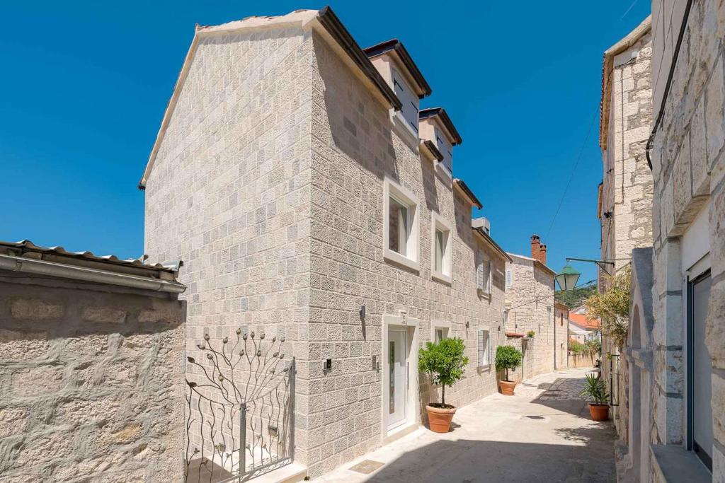 an alley in an old stone building with potted plants at Beautiful Hvar Villa 4 Bedrooms Villa Hvar Majestic Resort Centre Location & Wonderful Sea Views in Hvar