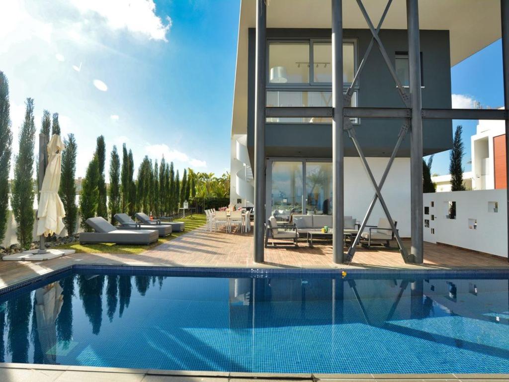 una casa con piscina accanto a un edificio di Villa Limni Dyo - Luxurious Contemporary 3 Bedroom Villa With Sea Views And Hot Tub a Paralimni