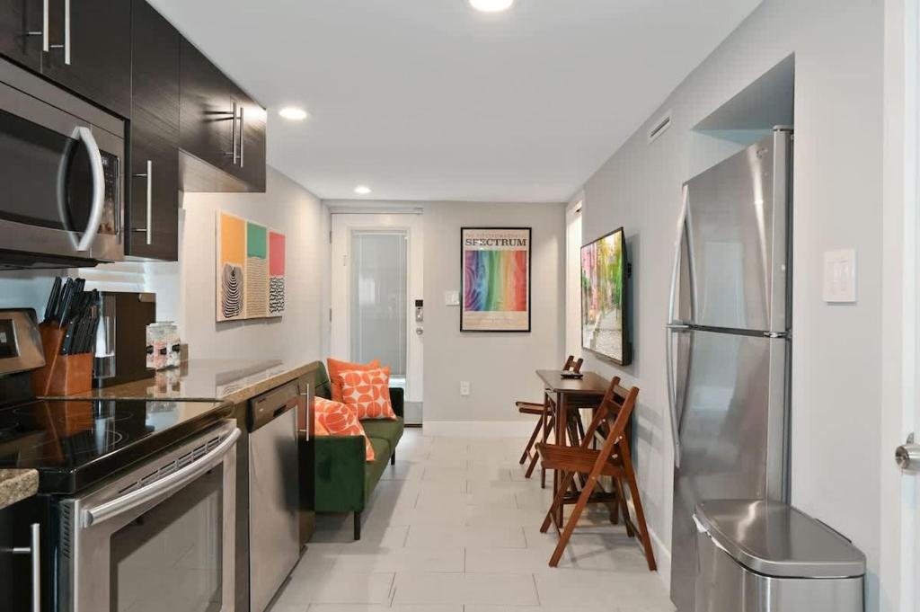 a kitchen with a refrigerator and a dining room at Cozy Mid-Century Apartment Steps From Restaurants #DCottage in Washington