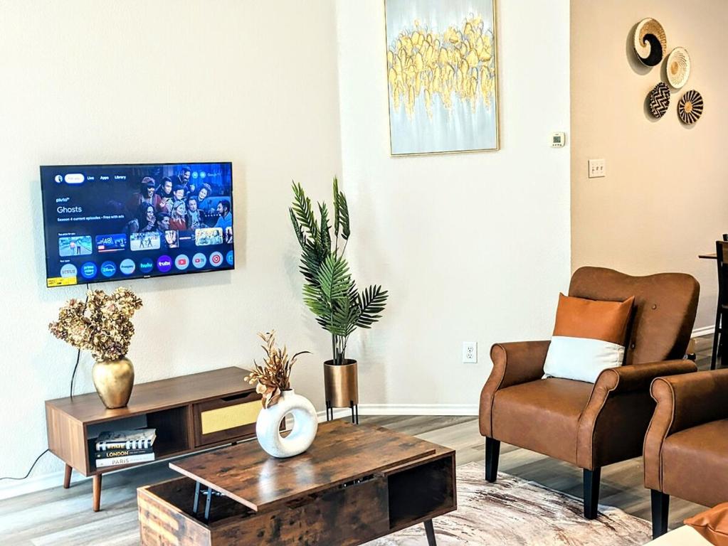 un soggiorno con 2 sedie e una TV di Luxury Living at Your Doorstep a Fort Worth