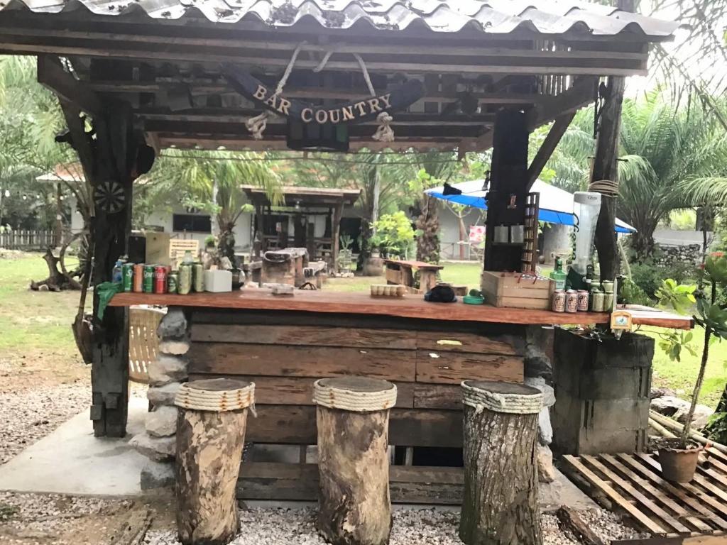 Un refugio para picnic con una mesa y dos troncos. en สบายคันทรีรีสอร์ท ปากเมงSa-buy country resort Pak Meng, en Sikao