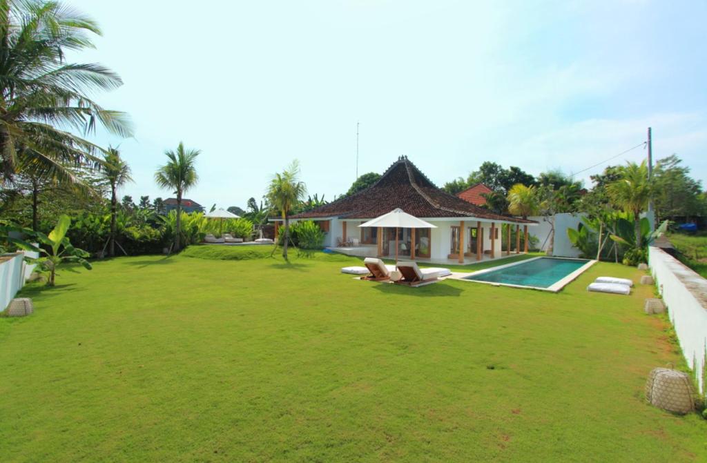 una casa con un gran patio con piscina en Love Is Simple Bali, en Canggu