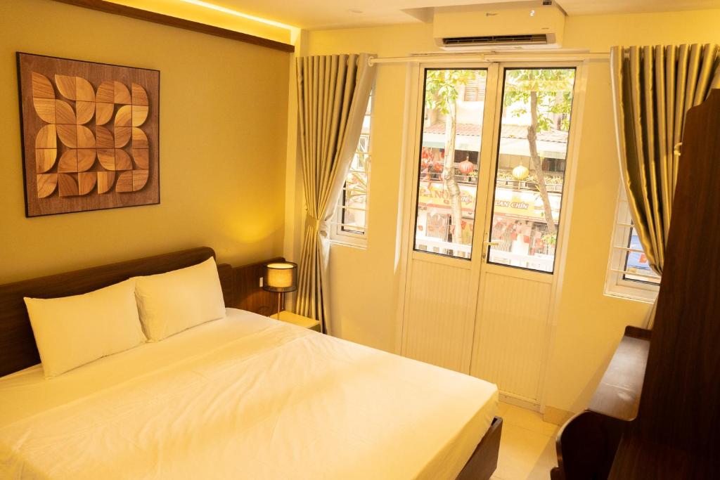 a bedroom with a white bed and a window at Bamboura Home in Hanoi