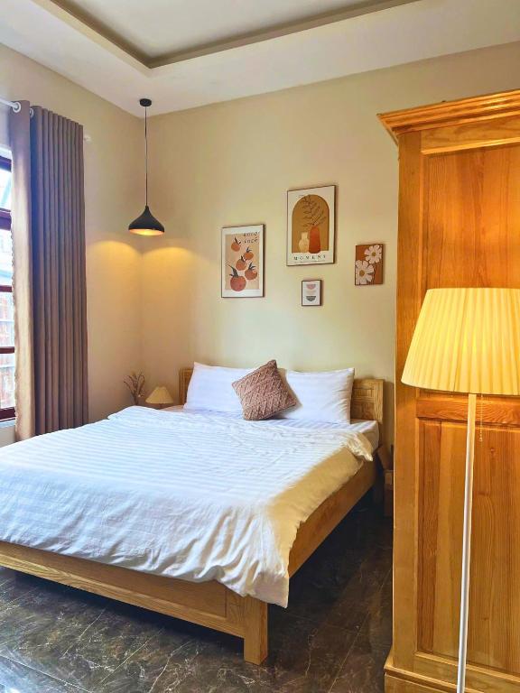 a bedroom with a bed and a lamp at The Brownhaven Đà Lạt in Da Lat