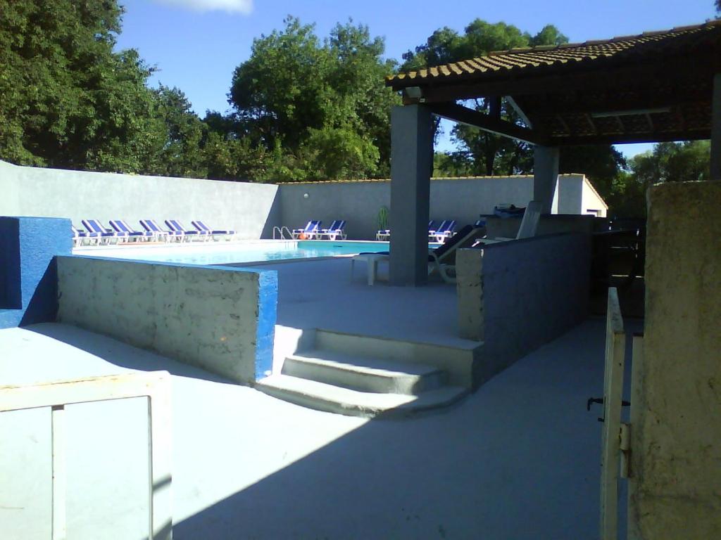 une piscine avec un pavillon et des escaliers à côté d'une piscine dans l'établissement Studio 10m2, terrasse 18m2 , parking, piscine et accueille les animaux, à Quissac