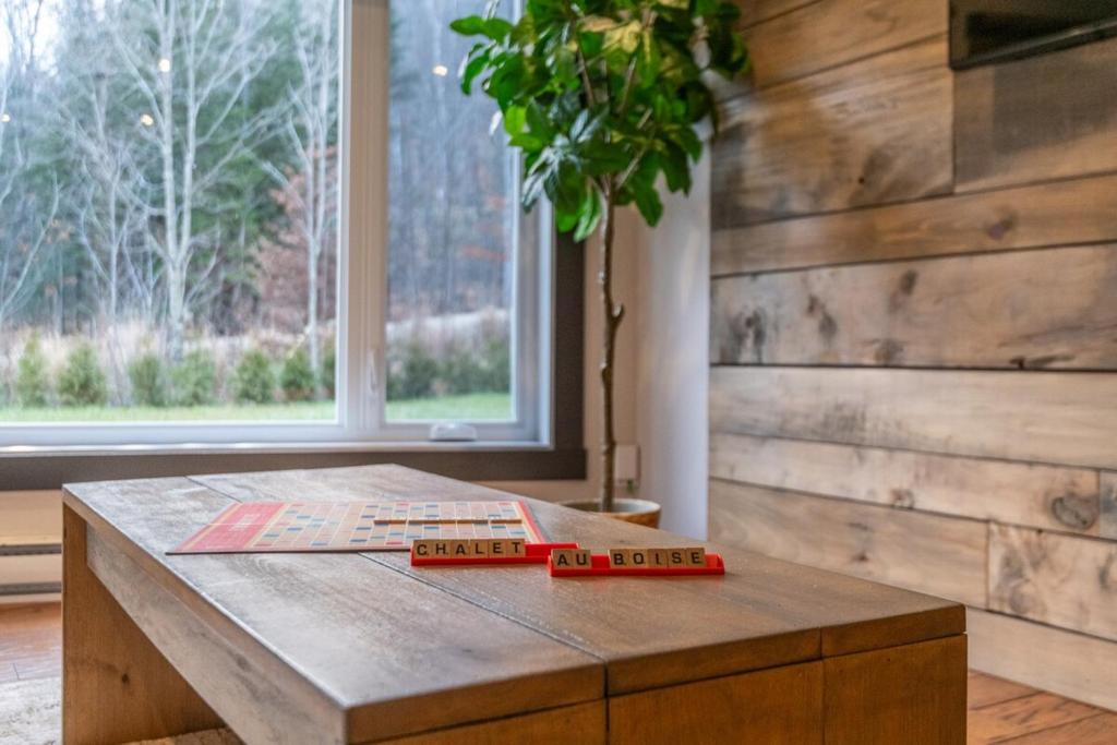a wooden table with a book on top of it at Chalet in the Woods, Serenity in Saint Come