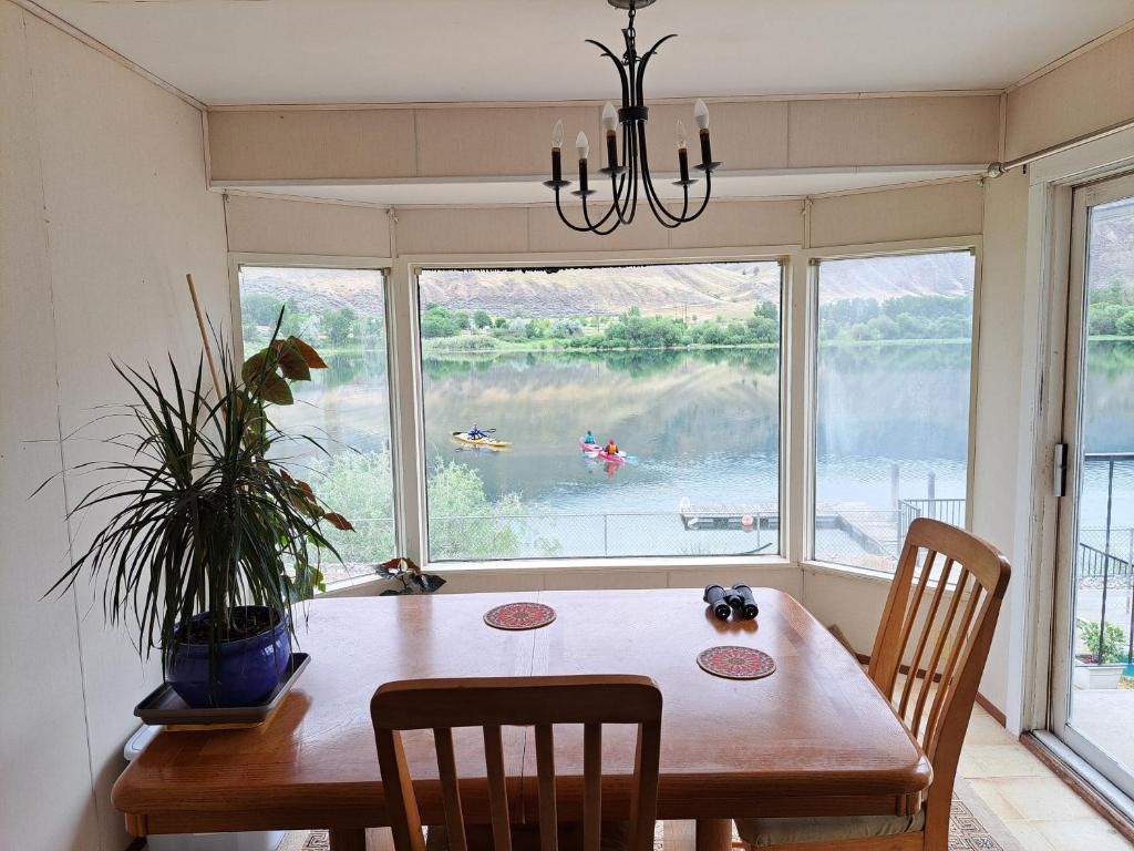 a dining room with a table and chairs and a large window at Private Bedroom at Riverfront House in Kamloops