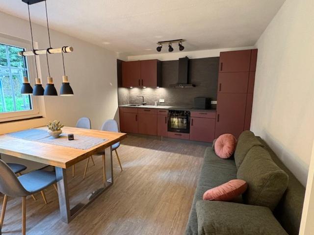 Una sala de estar con un sofá y una mesa y una cocina. en Landhaus Sommerberg, en Schleusingen