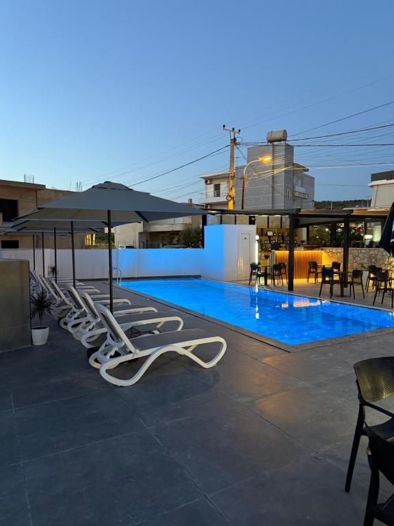 a row of lounge chairs next to a swimming pool at Suar Apartment in Ksamil