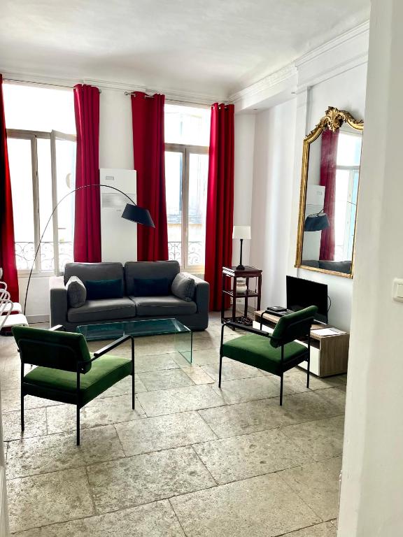 - un salon avec des rideaux rouges, un canapé et des chaises dans l'établissement La Canourgue, Appart de charme ,Parking gratuit, à Montpellier