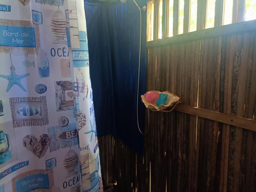 a room with a wooden fence and a curtain at La Maison de Morgana in Bemoko
