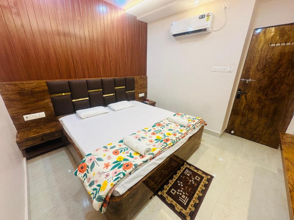 ein kleines Schlafzimmer mit einem Bett und einer Holztür in der Unterkunft Radhe Krishna Homestay in Varanasi