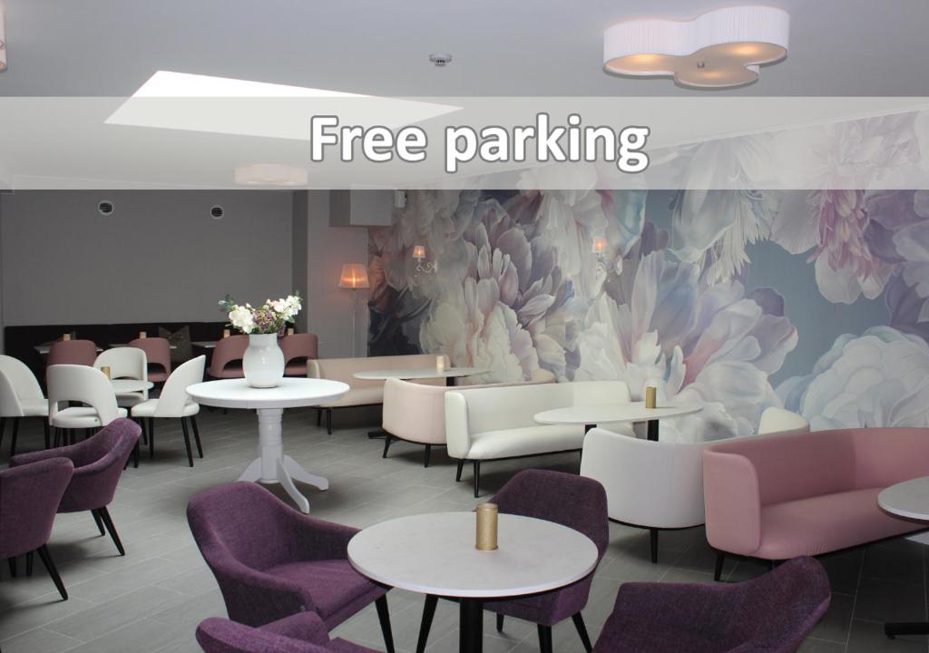 Un restaurante con mesas y sillas moradas y un mural. en Best Western Valhall Park Hotell, en Ängelholm