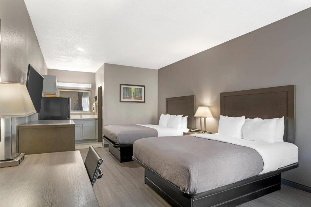 a hotel room with two beds and a television at Quality Inn Simpsonville-Greenville in Simpsonville