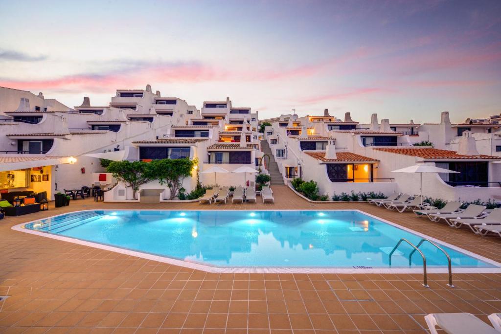a large pool in front of a group of white houses at 3HB Golden Beach in Albufeira