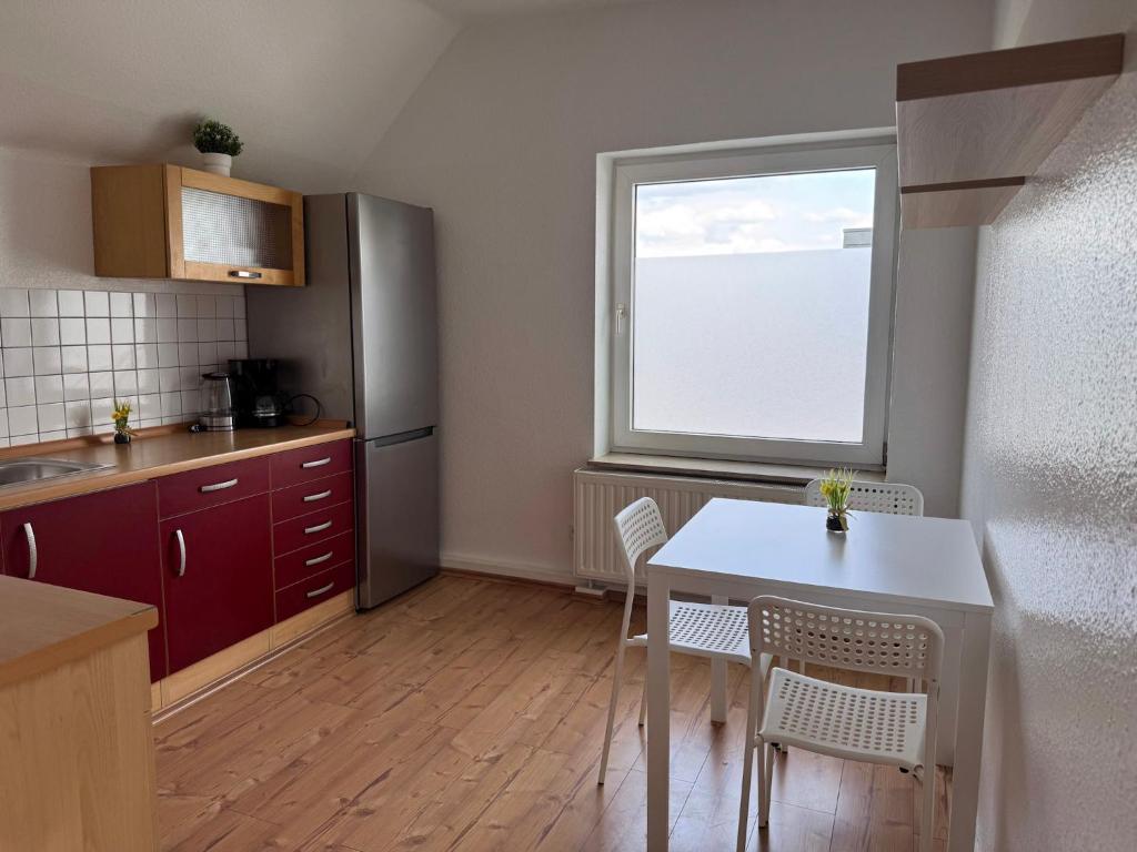 a kitchen with a table and chairs and a window at T&K Apartments - Nettetal - 3 Zimmer Wohnung - Privatparkplatz - 6 km bis Venlo in Nettetal