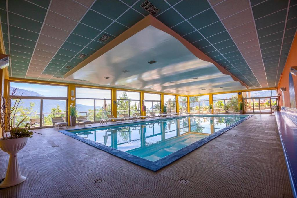 a large swimming pool in a building with windows at Residence Bellevue in Tremosine Sul Garda