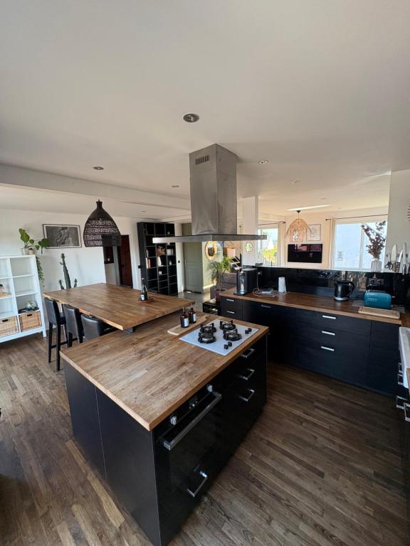 eine große Küche mit einer großen Holzinsel darin in der Unterkunft Charmante Maison Néo-bretonne in Perros-Guirec