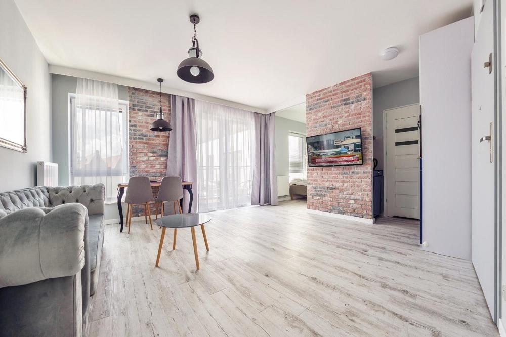 een woonkamer met een bank en een tafel bij Perfect Apartment Chmielna Park in Gdańsk