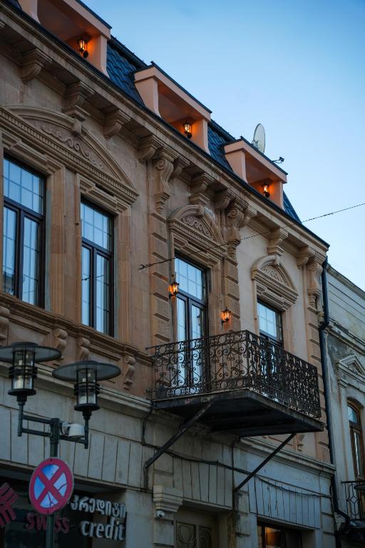 a building with a balcony on the side of it at Hotel BABU in Kutaisi