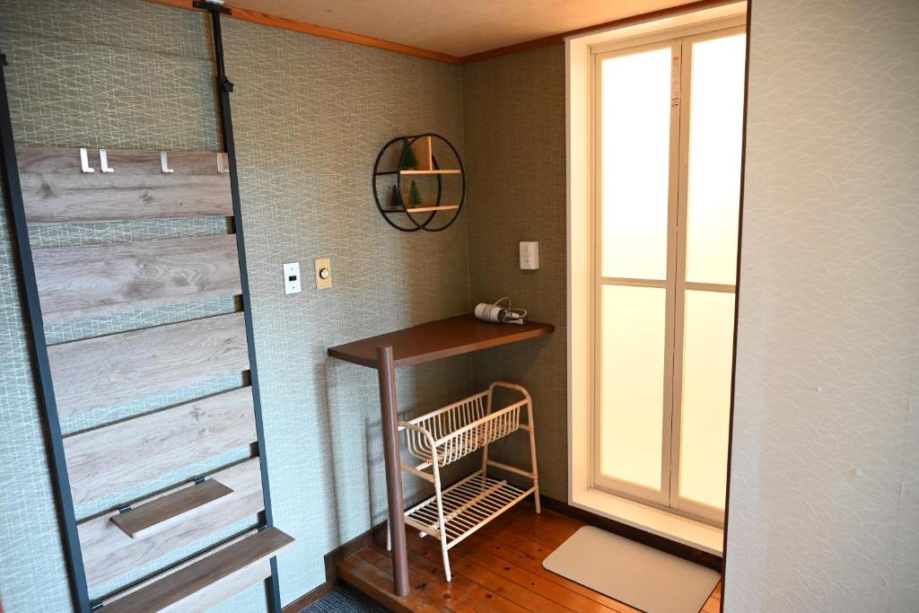 une petite salle de bains avec une table et une fenêtre dans l'établissement Kogakuro, à Myōkō
