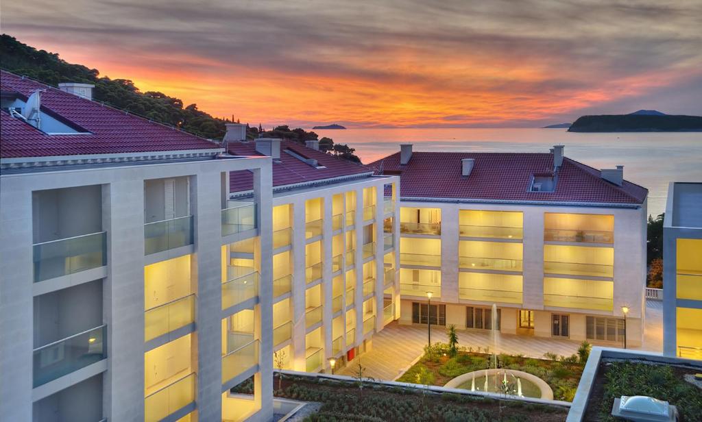 a view of a building with a sunset in the background at Flowers Dubrovnik Luxury Apartments in Dubrovnik
