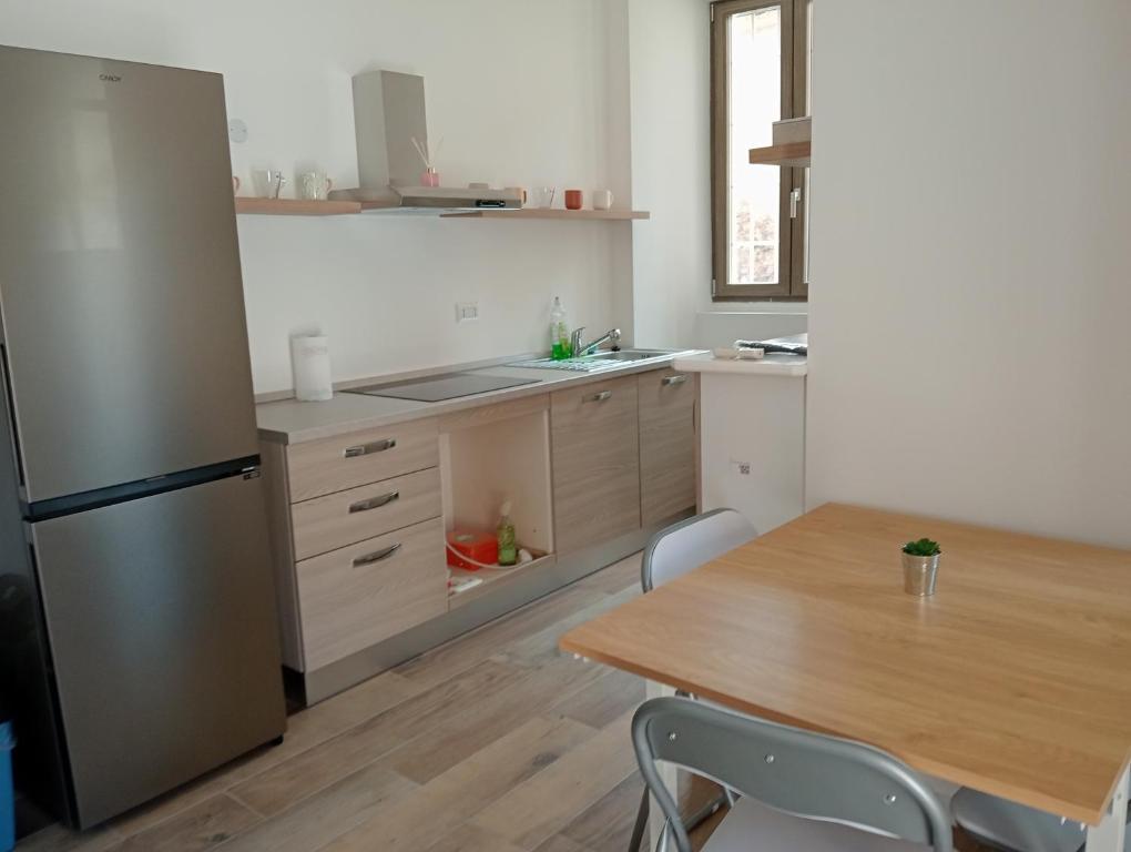 a kitchen with a wooden table and a refrigerator at Vi & Vi relax by the lake in Montorfano
