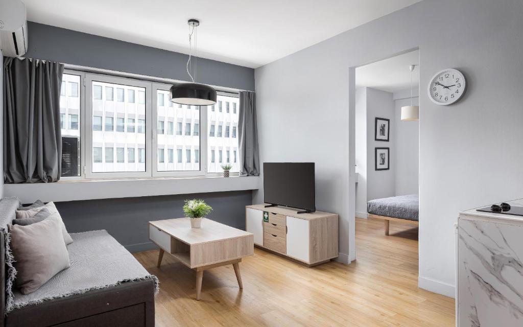 uma sala de estar com um sofá e uma TV em Standard Suite by Acropolis Cozy Suites em Atenas