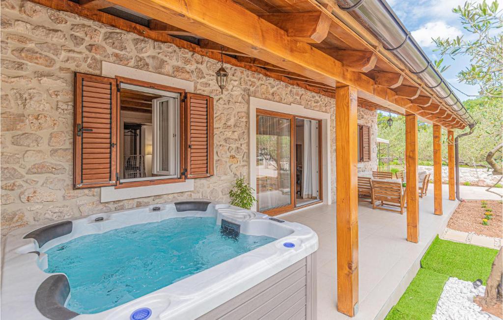 a hot tub on a patio with a house at Beautiful Home In Sibenik With Kitchen in Šibenik
