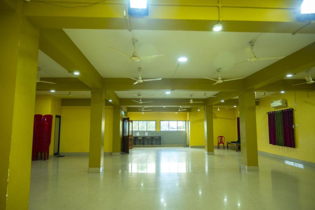 an empty room with yellow walls and yellow columns at Jalsa Lodge in Vishnupur