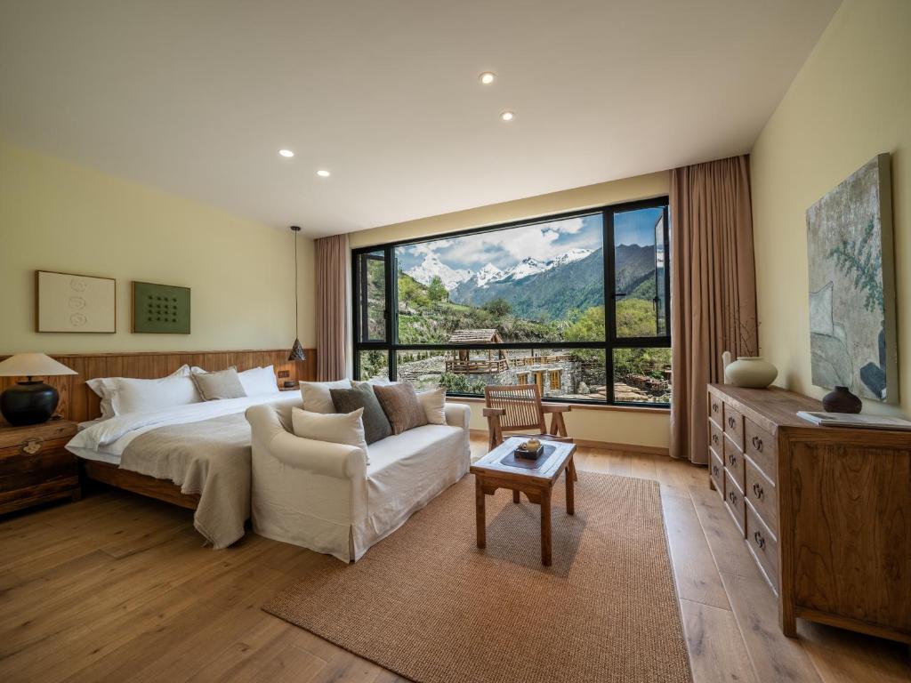 a large bedroom with a bed and a large window at Accommodation Shanlijian Holiday Homestay in Mount Siguniang